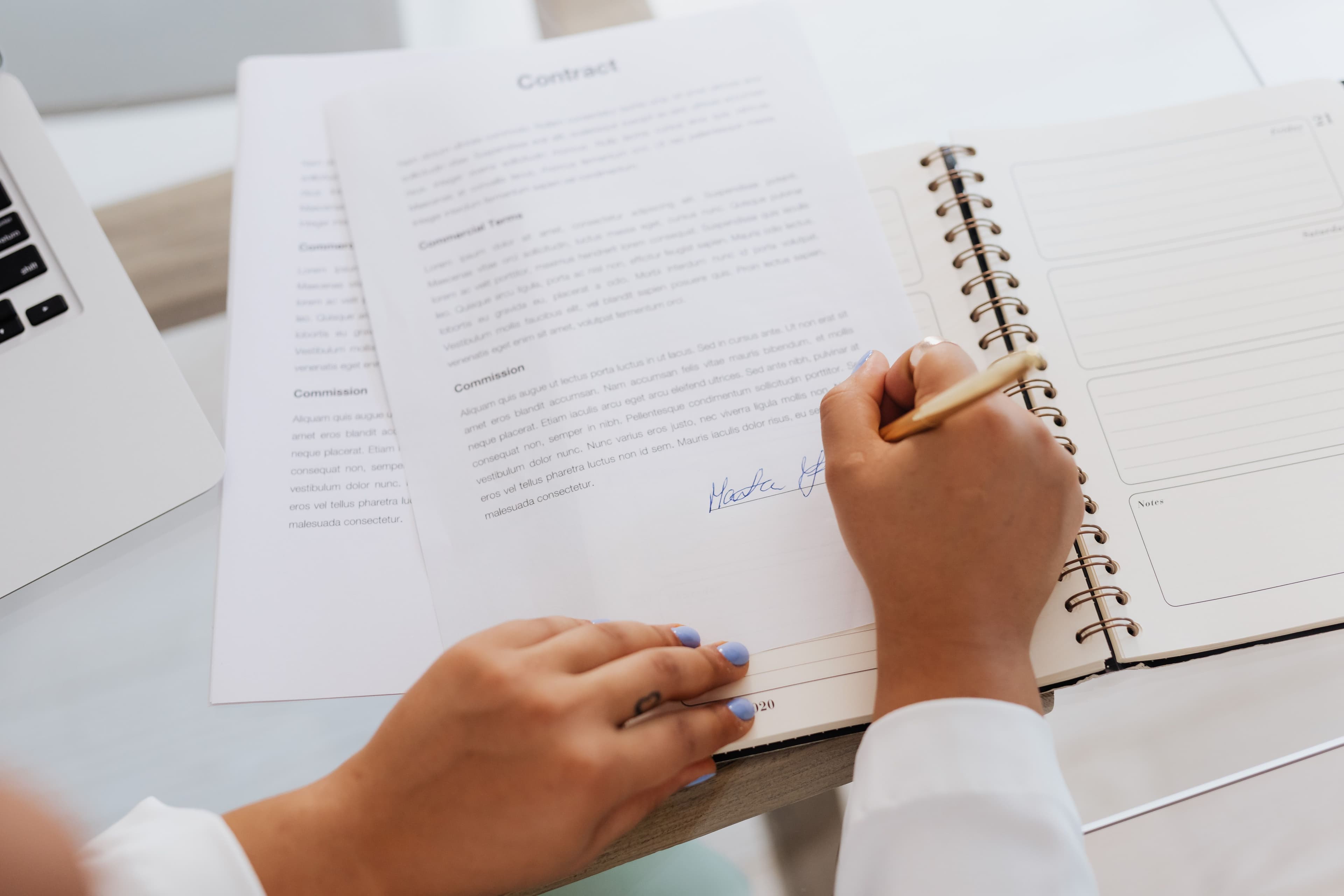 Close-up of hands signing an employment law document